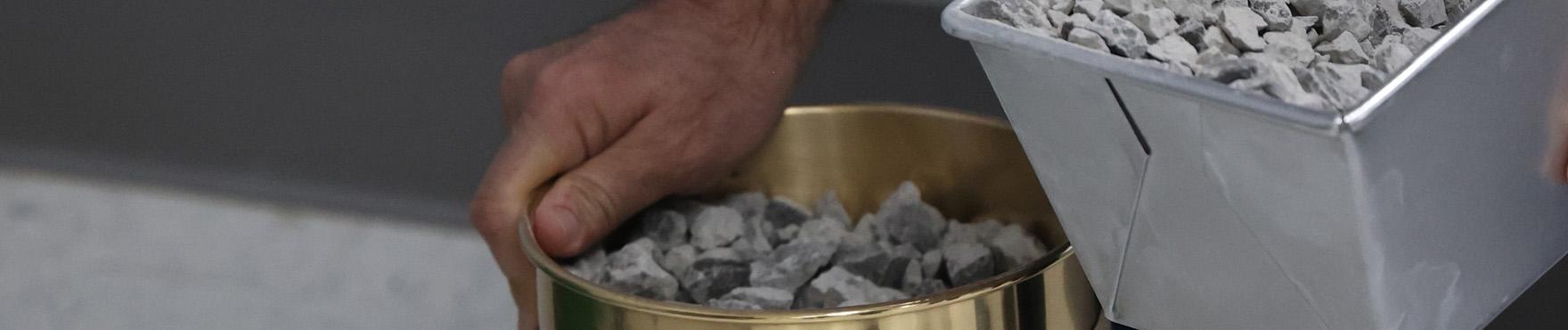 man pouring stones into a cylinder